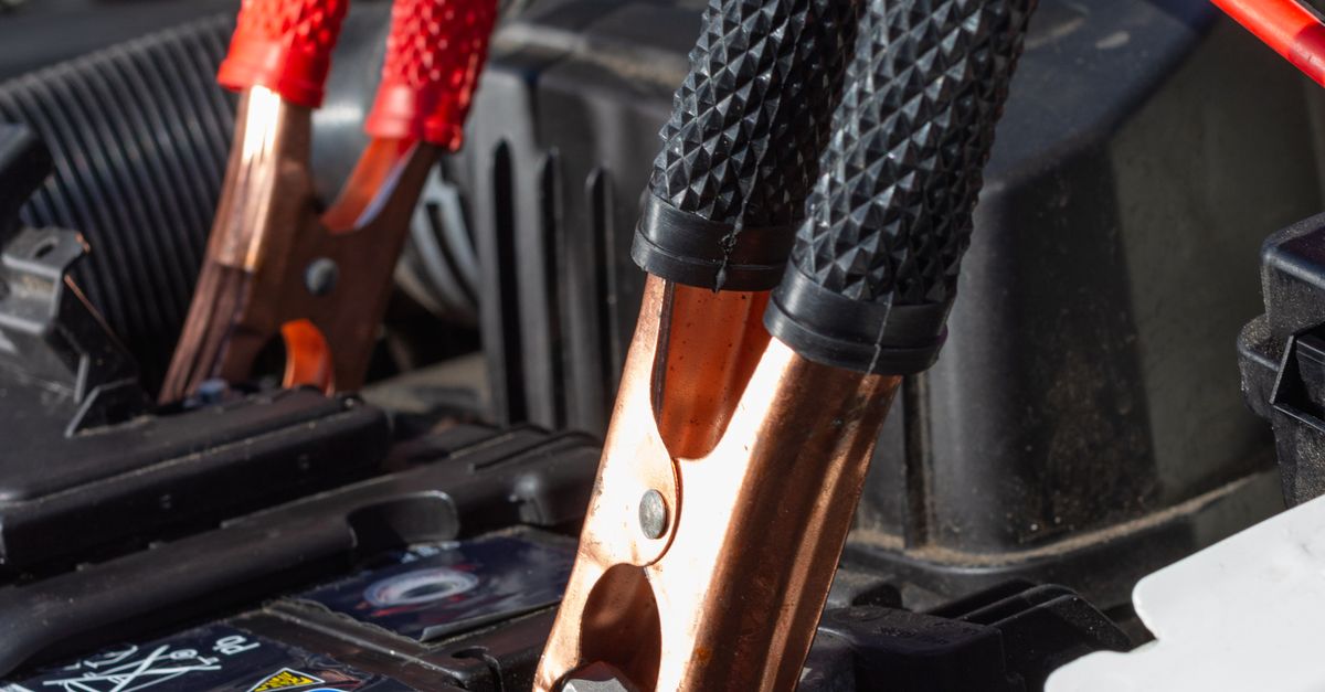 Close-up view of jumper cables charging a car battery.